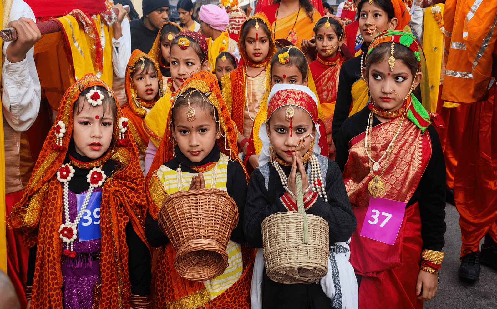 Children placing fresh flower petals on a decorated doorstep during Phool Dei celebrations